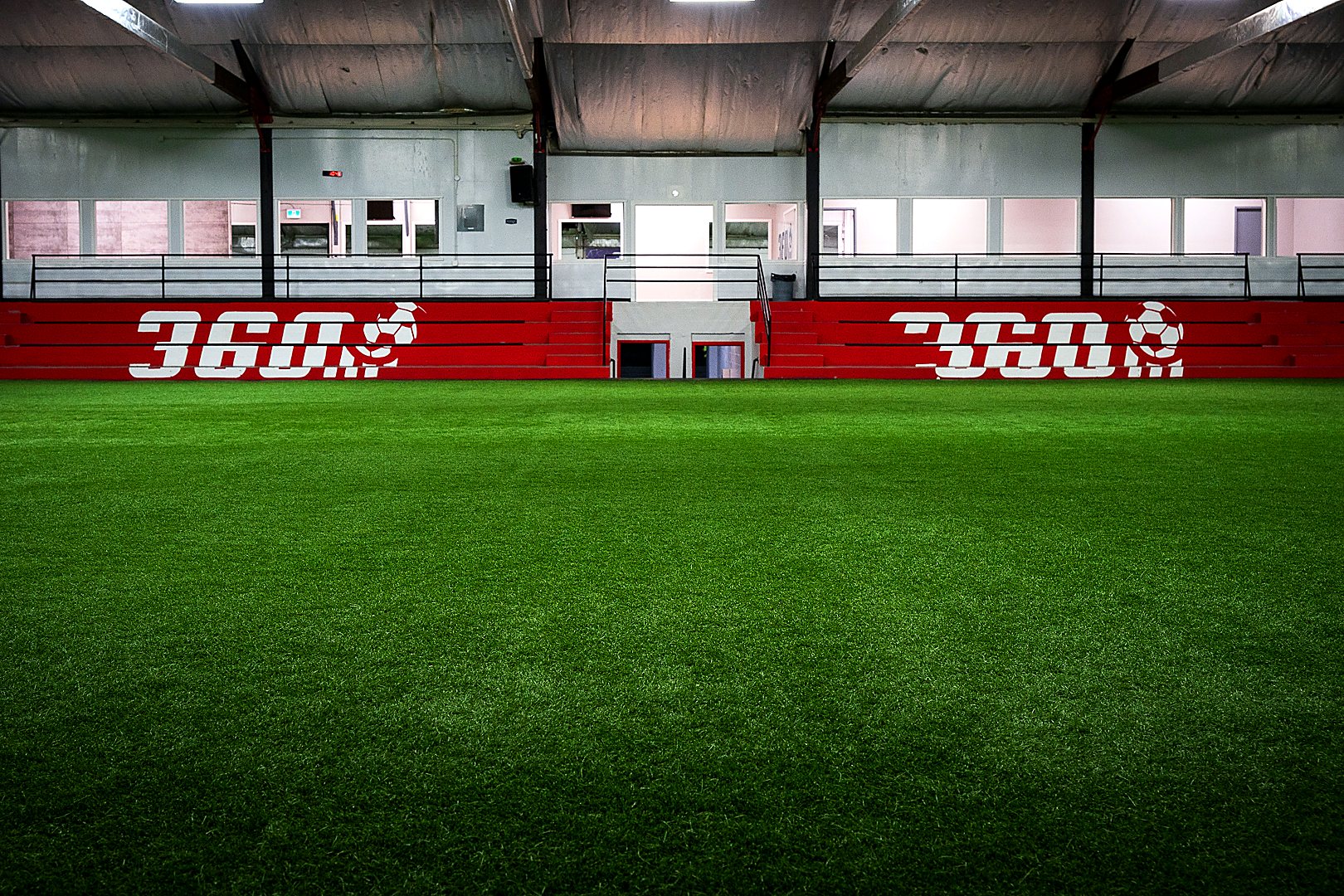 Red 360 spectator stands beside the indoor turf at 360 Vaughan